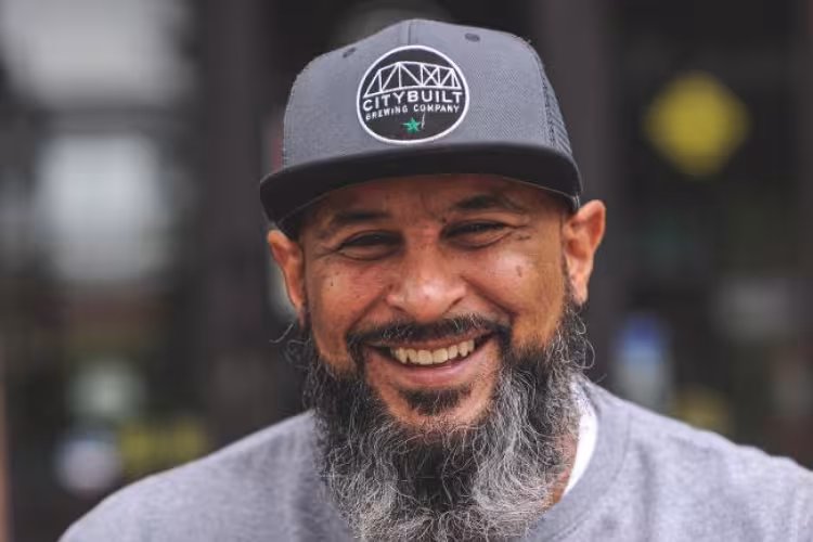 Edwin Collazo wearing a City Built Brewing cap.