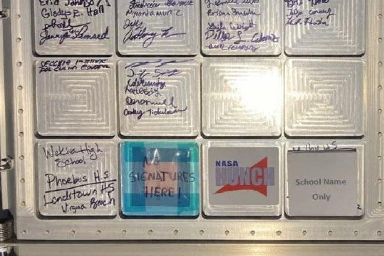 Signatures of GRCC students on NASA equipment, above the blue box. 