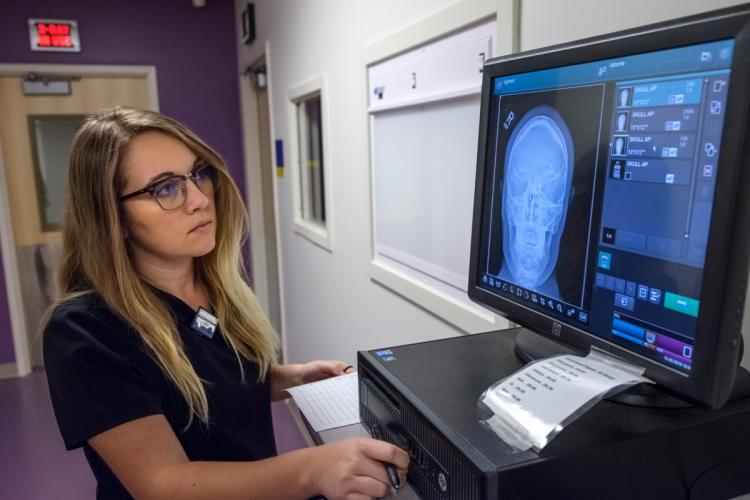 A rad tech student working on x-ray training equipment.