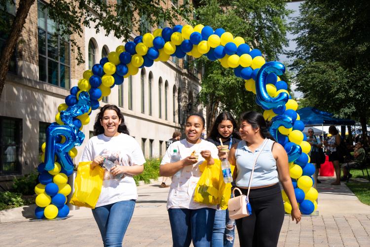 Students walking through a balloon arch at Raider Rally.