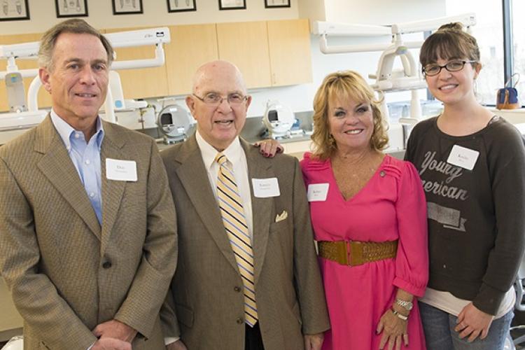 A group of four individuals standing in a dental lab.