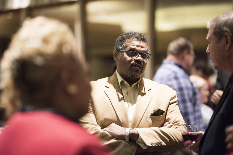 Rev. Nathaniel Moody speaking with colleagues at a reception.