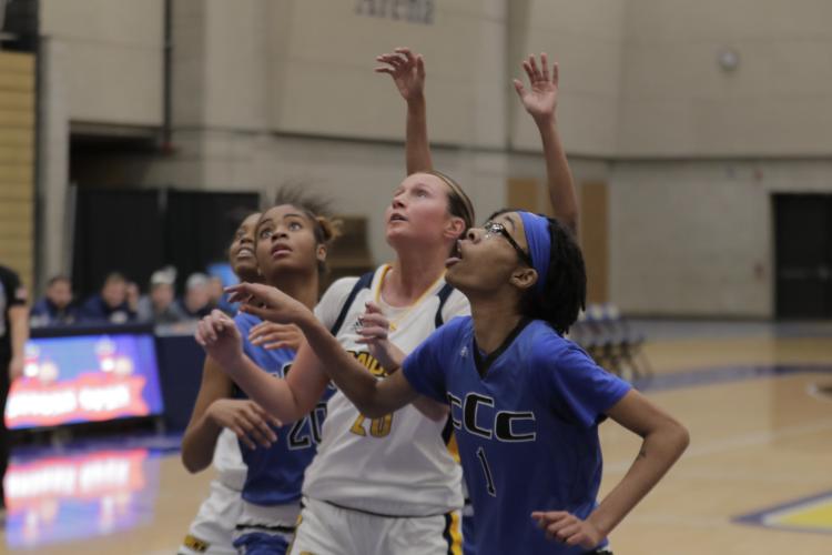 Sally Merrill among defenders looking up at a shot.