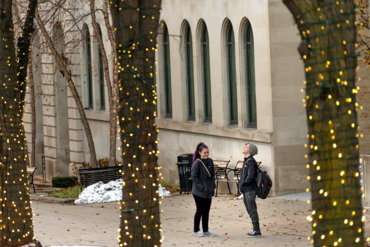 Students on Olivarez Plaza with lighted trees. 