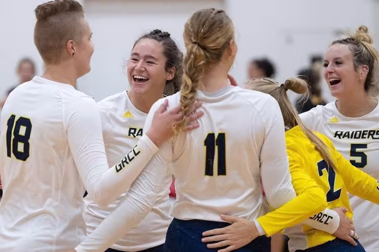Volleyball team members celebrating after scoring a point.