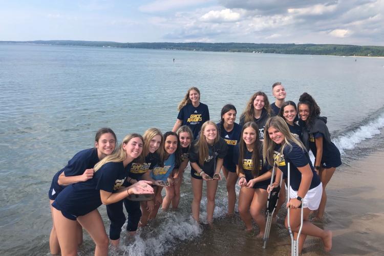 GRCC volleyball team members collecting Petoskey stones before their match.