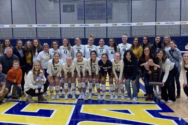 Current GRCC volleyball players surrounded by alumni.