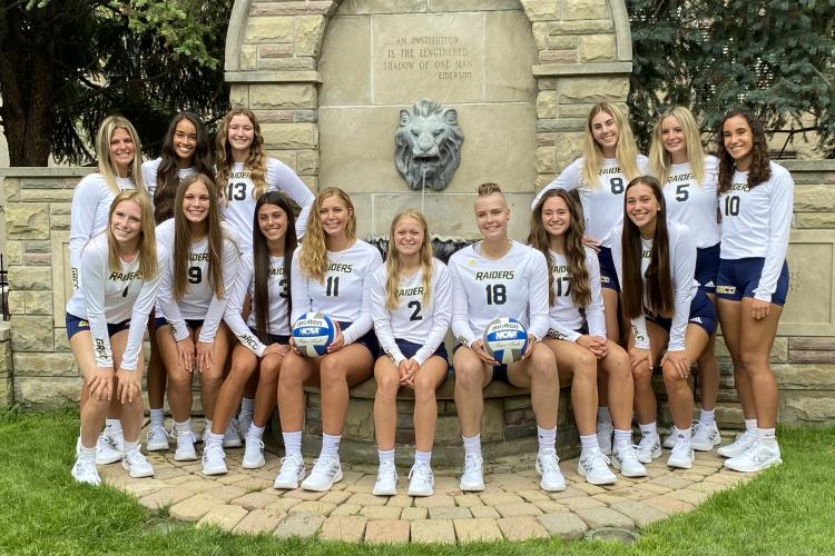 Volleyball team posing by the lion fountain.