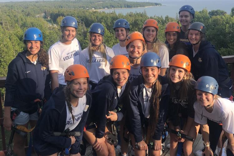 Volleyball team members in St. Ignace before riding a zip line. 