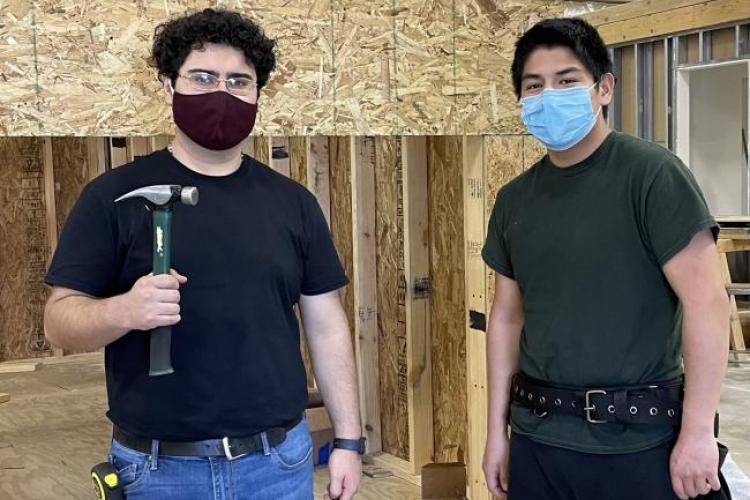 Kenneth Lara and Francisco Mendez in the construction classroom with tools.
