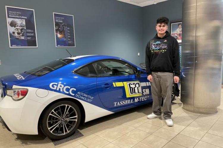 Francisco Sainz posting with a car in the Tassell M-TEC.
