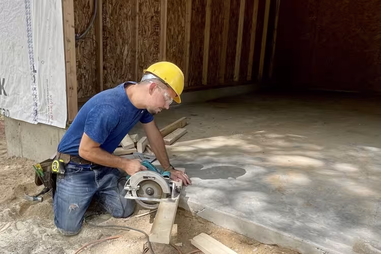 Joshua Middleton working with a saw on a construction project.