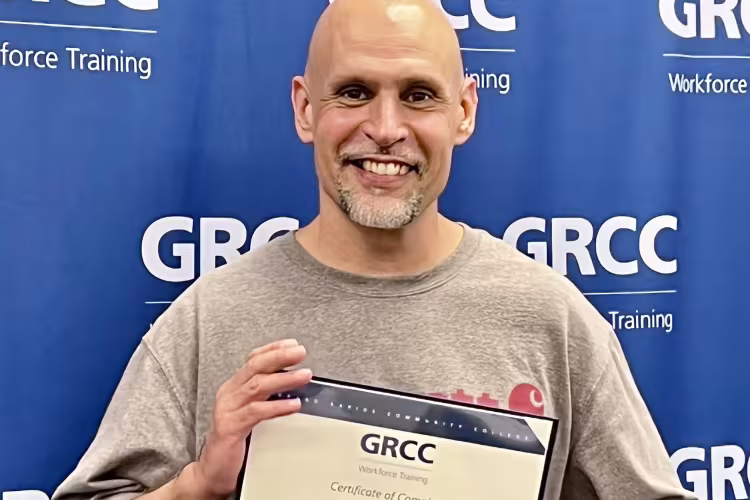 David Puente holding his diploma.