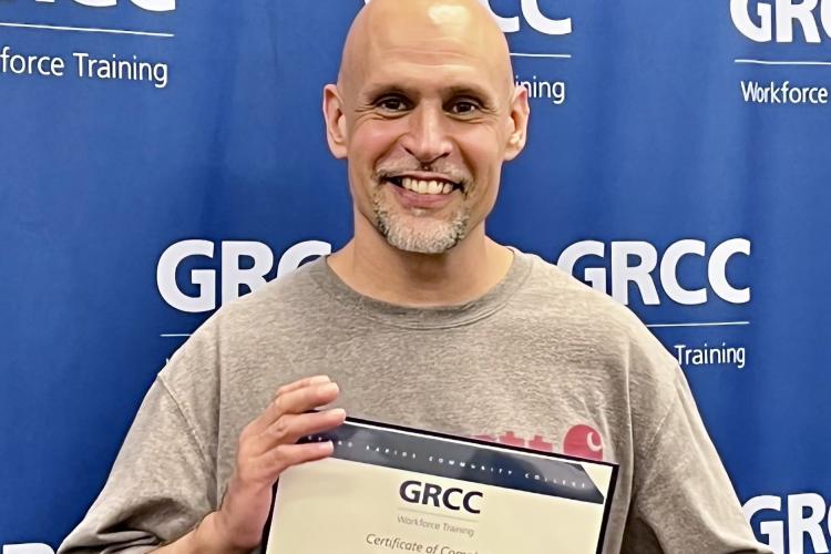 David Puente holding his diploma.