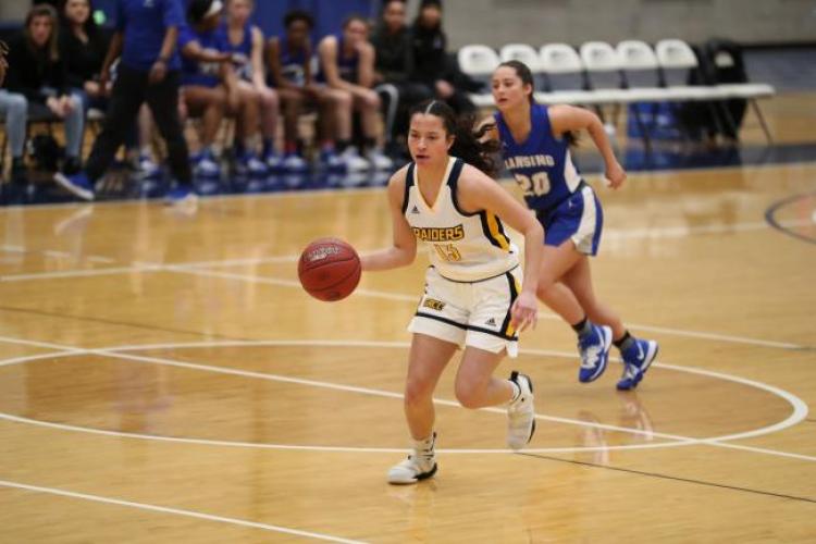Basketball player Jamie Wellet driving down the court.