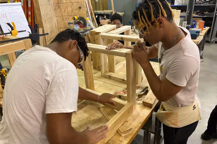 Zeke Grandy and Malik Campbell working in the wood camp.