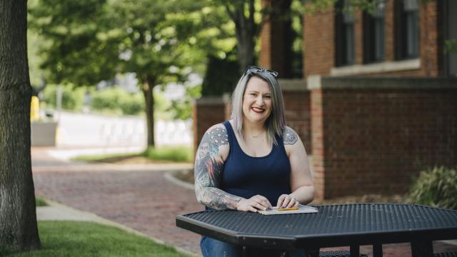A person sits at an outdoor table.