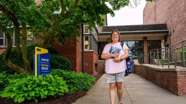 Student on the DeVos Campus outside of Sneden Hall