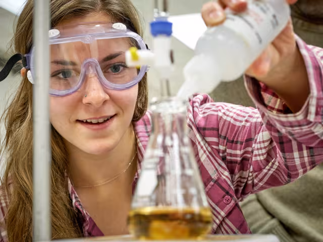 GRCC student adding solution to a beaker.