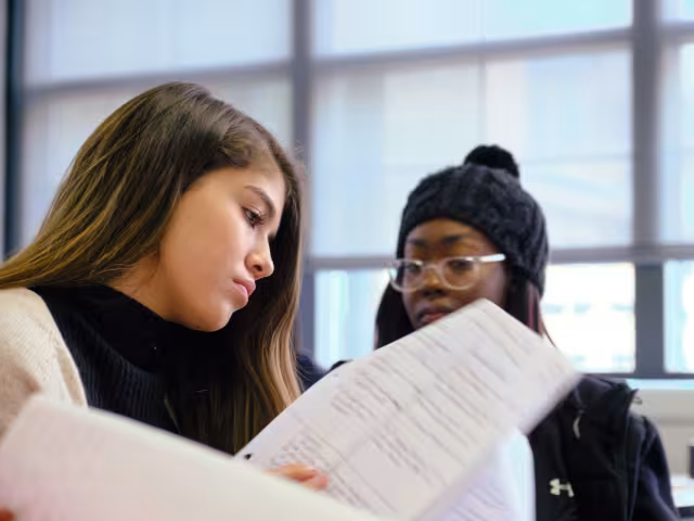 Students reviewing a paper.