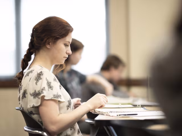 Student looking at a book in class