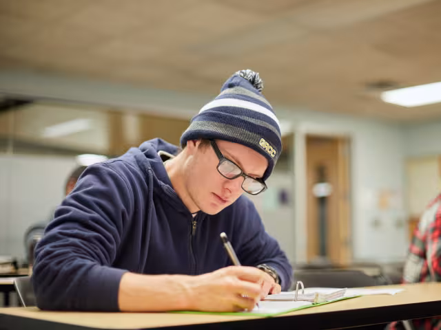 GRCC student writing in  a notebook