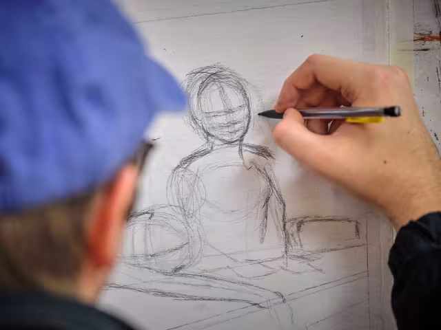 Student sketches with pencil and paper.