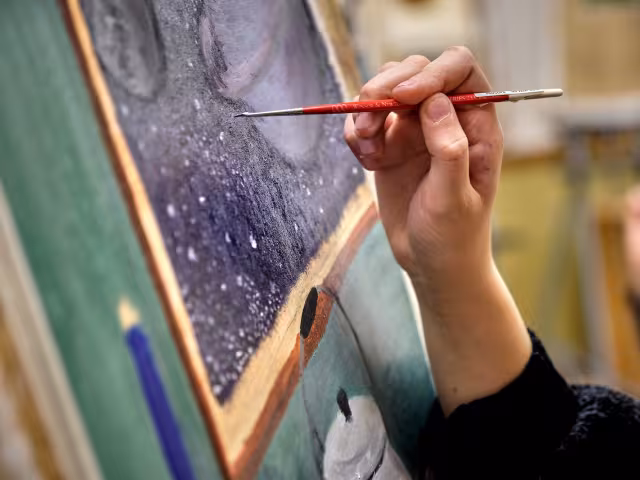 Student painting a canvas.