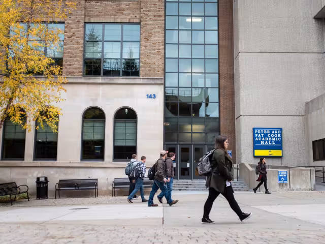 Students walking in front of the Peter and Pat Cook Academic Hall.