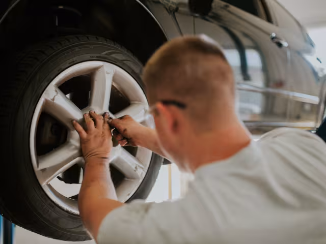 Student replacing a tire of a car at the MTEC