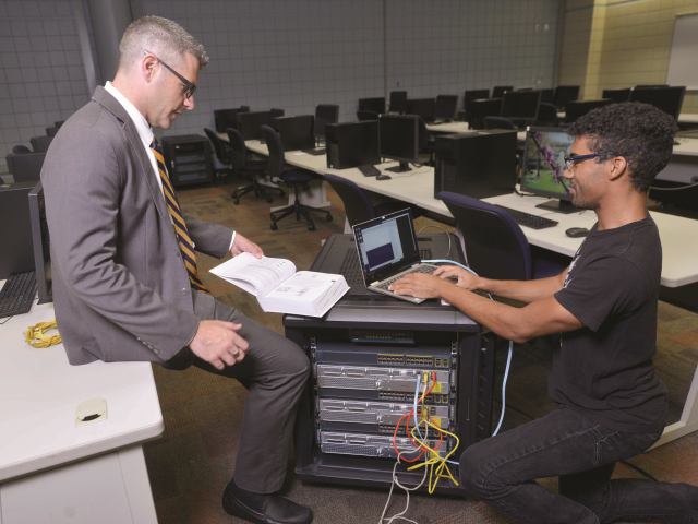 Student works with Professor Rozema on a server.