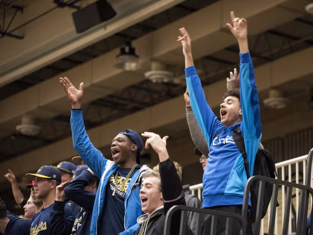 Students cheering on the Women's Volleyball team on Homecoming.