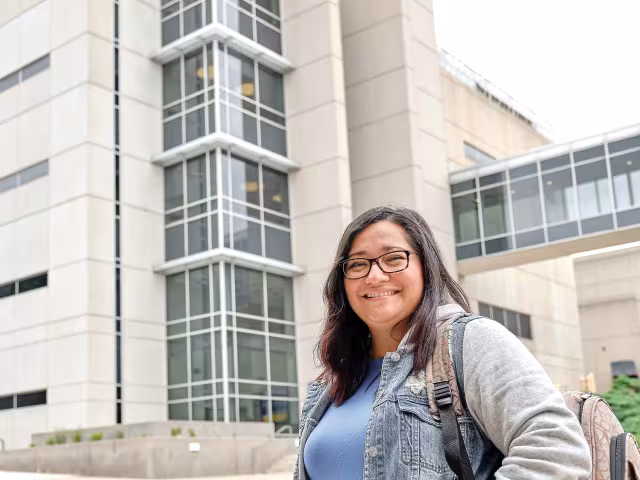 Student smiles outside of Calkins Hall.