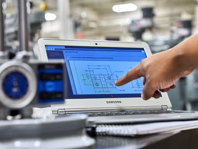 Manufacturing student looking a computer blueprint