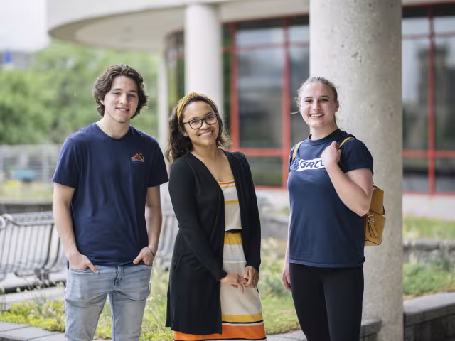 A group of young GRCC students smiles confidently into the camera.
