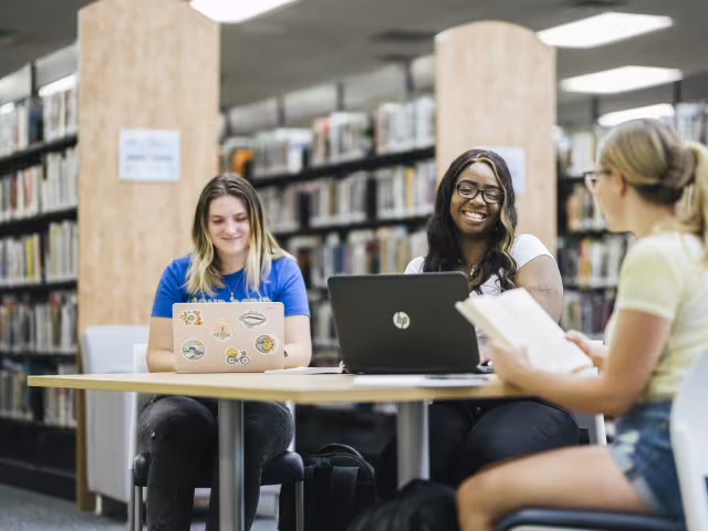 Students on laptops in library.
