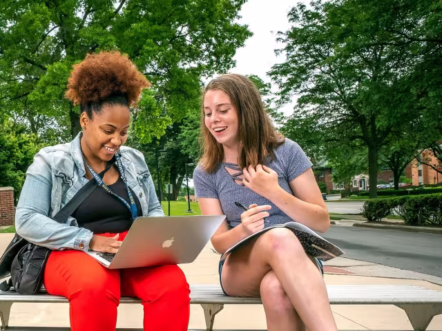 Two students looking a ta laptop
