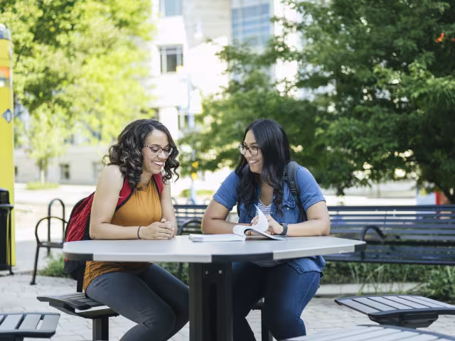 Students doing homework together outside of RJF on a summer day.
