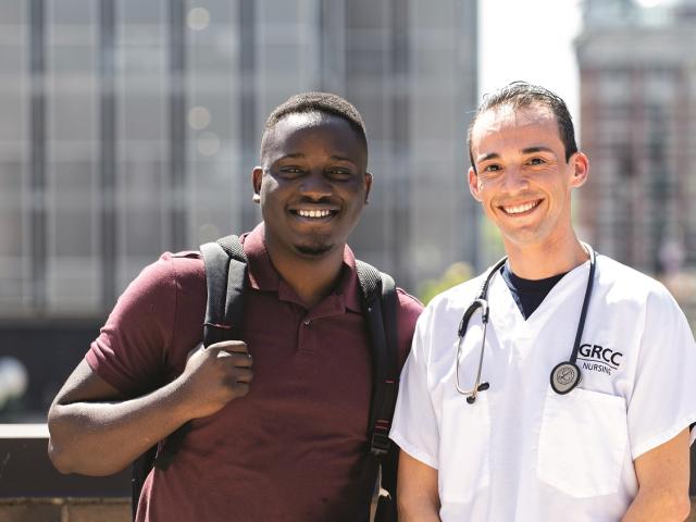 Two students standing outside with downtown view as the backdrop.