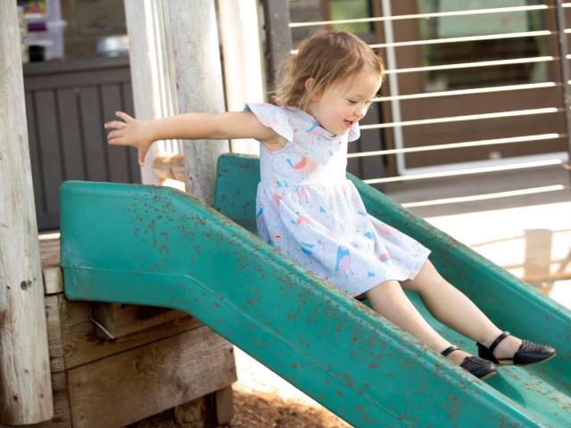 Preschooler on the the slide in playground