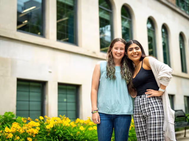 Two students hugging and smiling outside RJF Hall