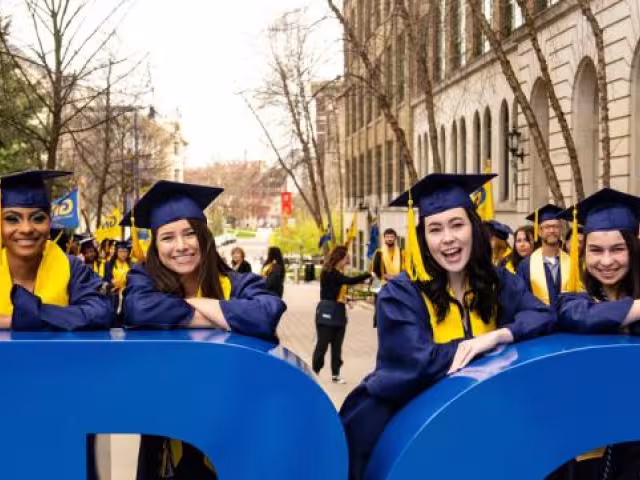 GRCC students standing in front of the GRCC campus sign