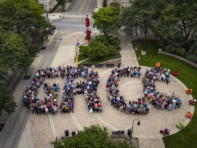 People standing in groups spelling out GRCC