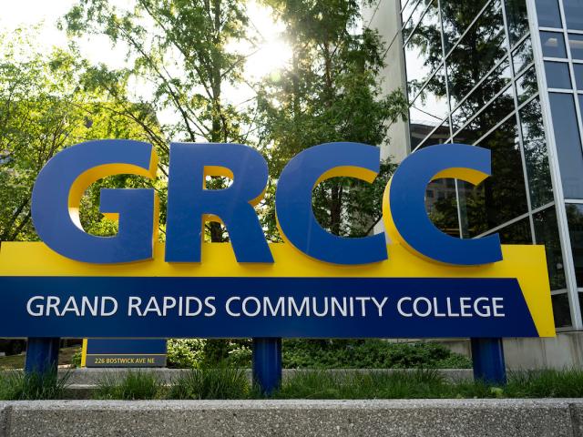 A blue and gold sign that says GRCC: Grand Rapids Community College is shown on campus.