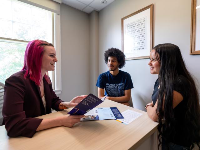 hree Promise Zone students talking at a table.