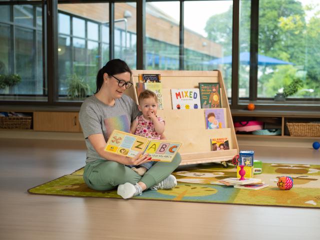 Early education student reading to an infant
