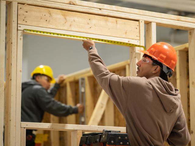 Residential construction student measuring a door frame