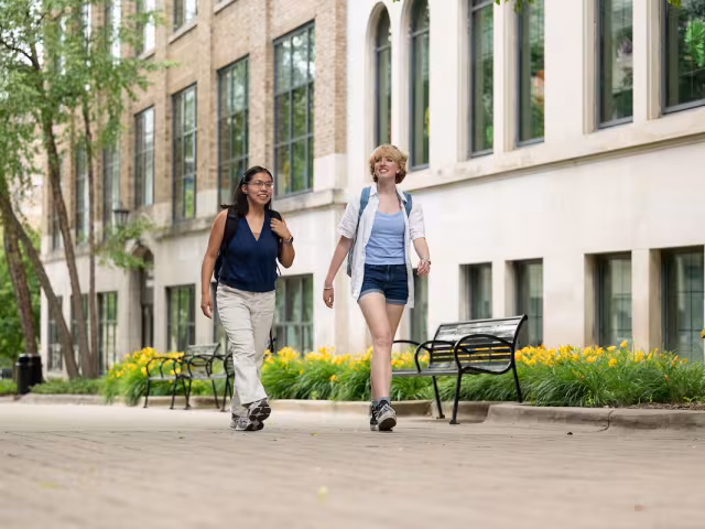 Two students walk together on campus.