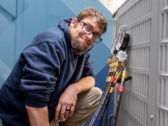 HVAC student work on an AC unit