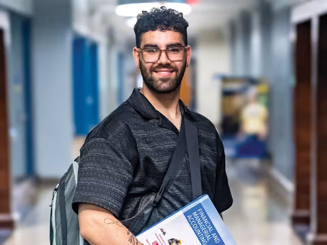 Student carrying a book in the Business Center